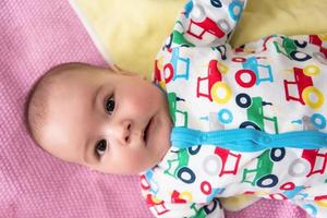 top view of newborn baby boy lying on colorful blankets photo