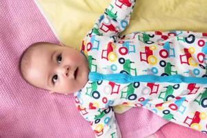 top view of newborn baby boy lying on colorful blankets photo