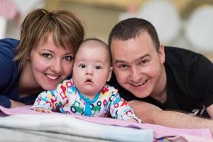 Portrait of young happy couple with their adorable baby boy photo