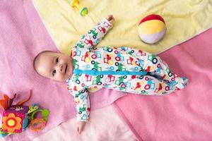 top view of newborn baby boy lying on colorful blankets photo