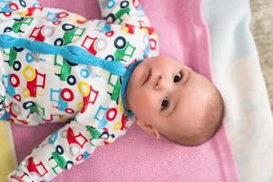 top view of newborn baby boy lying on colorful blankets photo