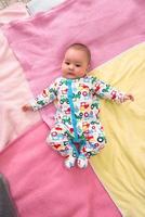 top view of newborn baby boy lying on colorful blankets photo