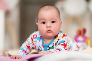 newborn baby boy playing on the floor photo