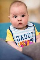 baby boy sitting between the pillows on sofa photo