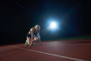 woman  sprinter leaving starting blocks photo