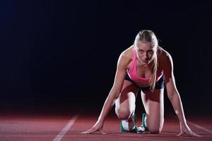 Photo of woman sprinter leaving starting blocks