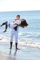 feliz pareja joven divertirse en la hermosa playa foto