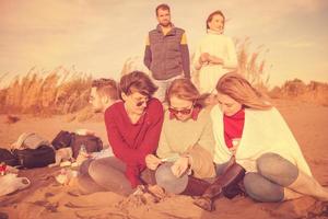 Friends having fun at beach on autumn day photo