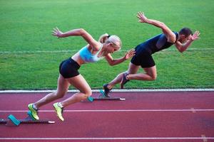 woman group  running on athletics race track from start photo