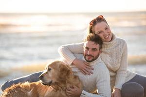 Couple with dog enjoying time on beach photo