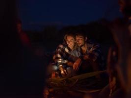 pareja disfrutando con amigos por la noche en la playa foto