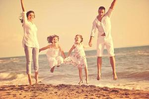 familia joven feliz divertirse en la playa foto