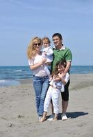 familia joven feliz divertirse en la playa foto