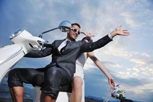 just married couple on the beach ride white scooter photo