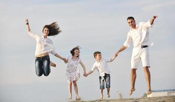 familia joven feliz divertirse en la playa foto