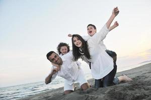 familia joven feliz divertirse en la playa foto