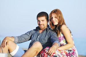 feliz pareja joven tiene tiempo romántico en la playa foto