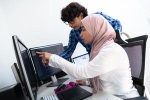 negocio de inicio, jóvenes profesionales creativos equipo de personas discutiendo sobre reunirse en una oficina brillante mientras señalan en una computadora de pantalla de monitor dual para sugerencias y ayuda en el proyecto foto