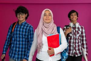 A group of Arab teenagers, a student team walking forward into the future and back to school the concept of a pink background. The concept of successful education for young people. Selective focus photo