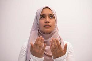 Arab female Muslim in traditional hijab clothes praying namaz dua open hands to Allah photo