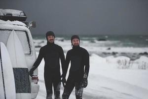Arctic surfers in wetsuit after surfing by minivan photo