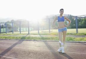 mujer joven feliz en la pista de carreras atléticas foto