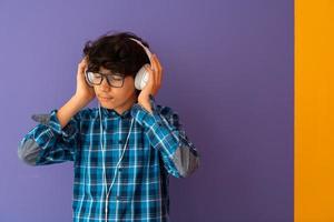 Teenage Boy Wearing Headphones And Listening To Music purple background photo