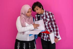 Arabic teenagers group, students team walking forward in future and back to school concept pink background. Selective focus photo