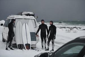 Arctic surfers in wetsuit after surfing by minivan photo