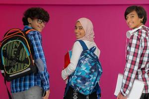 A group of Arab teenagers, a student team walking forward into the future and back to school the concept of a pink background. The concept of successful education for young people. Selective focus photo