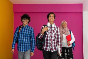 A group of Arab teenagers, a student team walking forward into the future and back to school the concept of a pink background. The concept of successful education for young people. Selective focus photo