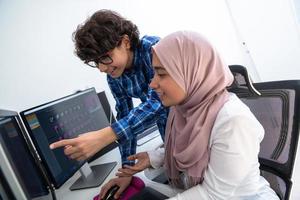 negocio de inicio, jóvenes profesionales creativos equipo de personas discutiendo sobre reunirse en una oficina brillante mientras señalan en una computadora de pantalla de monitor dual para sugerencias y ayuda en el proyecto foto