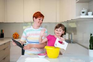 niña y mamá haciendo pastel de tastz en familia kithen divirtiéndose en casa foto