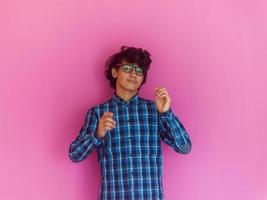 Arabic Teenage Boy Wearing Headphones And Listening To Music pink background photo