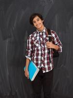 adolescente árabe con mochila con aspecto escolar informal contra fondo de pizarra negra foto