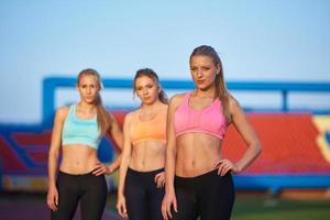 athlete woman group  running on athletics race track photo