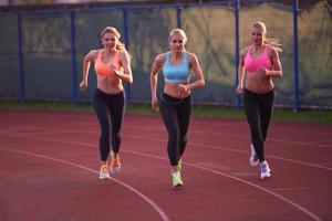 athlete woman group  running on athletics race track photo