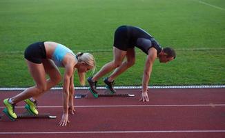 grupo de mujeres atletas corriendo en la pista de carreras de atletismo foto