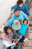 foto de vista superior de una familia árabe sentada en la sala de estar de una casa grande y moderna. enfoque selectivo