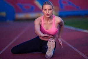 mujer deportiva en pista de carreras atléticas foto