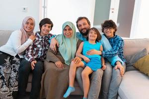 Portrait photo of an arab muslim family sitting on a couch in the living room of a large modern house. Selective focus