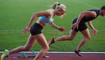 grupo de mujeres atletas corriendo en la pista de carreras de atletismo foto