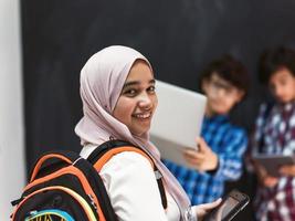 Modern arab teens use smartphone, tablet and latpop to study during online classes due to corona virus pandemic photo
