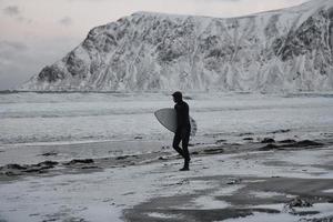 Arctic surfer going by beach after surfing photo