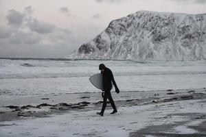 Arctic surfer going by beach after surfing photo