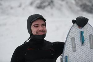 Arctic surfer portrait holding a board after surfing in Norwegian sea photo