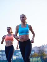 grupo de mujeres atletas corriendo en la pista de carreras de atletismo foto