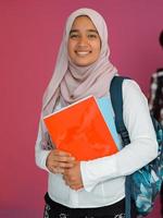 A group of Arab teenagers, a student team walking forward into the future and back to school the concept of a pink background. The concept of successful education for young people. Selective focus photo