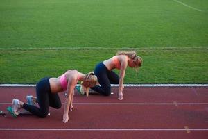 athlete woman group  running on athletics race track photo