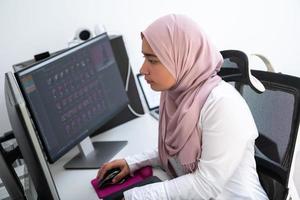 profesional creativa árabe femenina que trabaja en la oficina en casa en una computadora de escritorio con vista superior de monitor de pantalla dual. enfoque selectivo foto